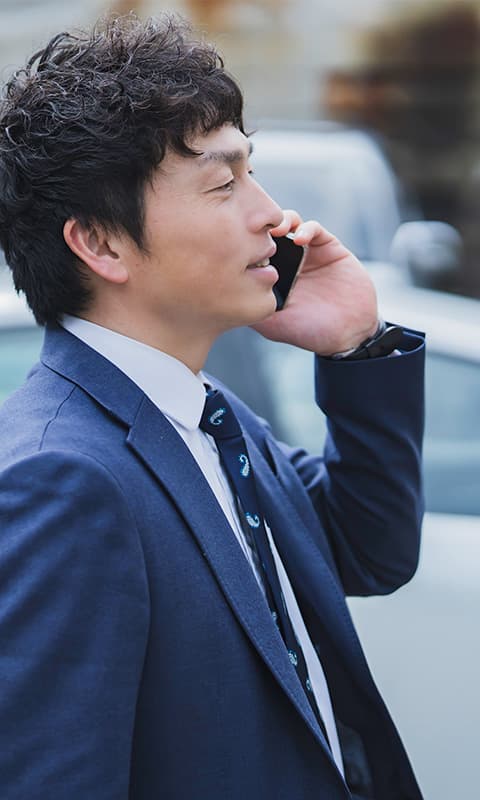 スーツ姿の男性がスマホで話をしている様子