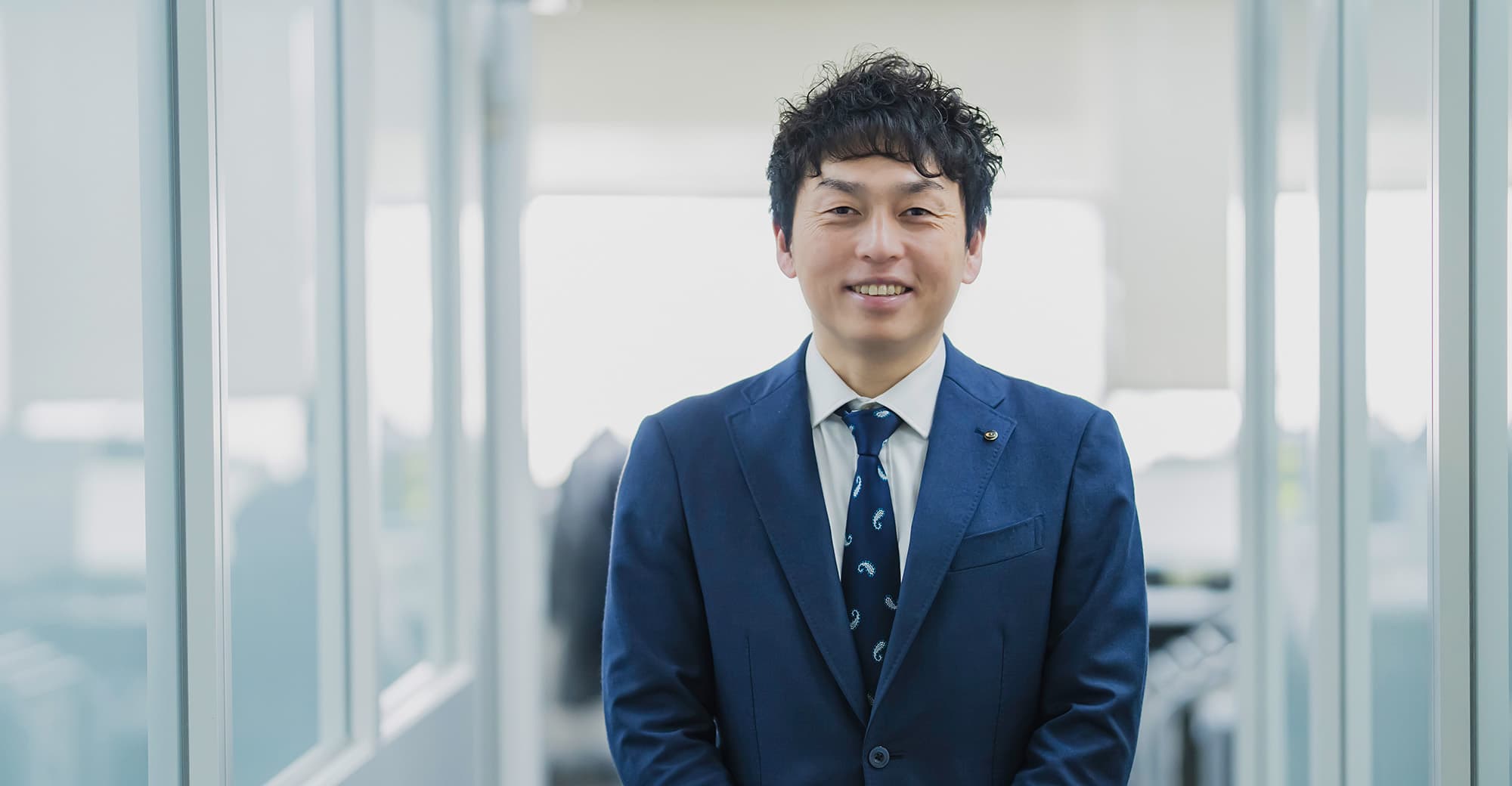 ほほ笑んでいるスーツ姿の男性